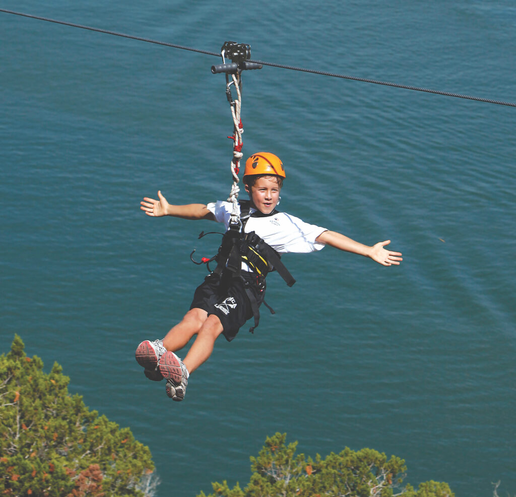 10 year-old boy ziplining across Lake Travis