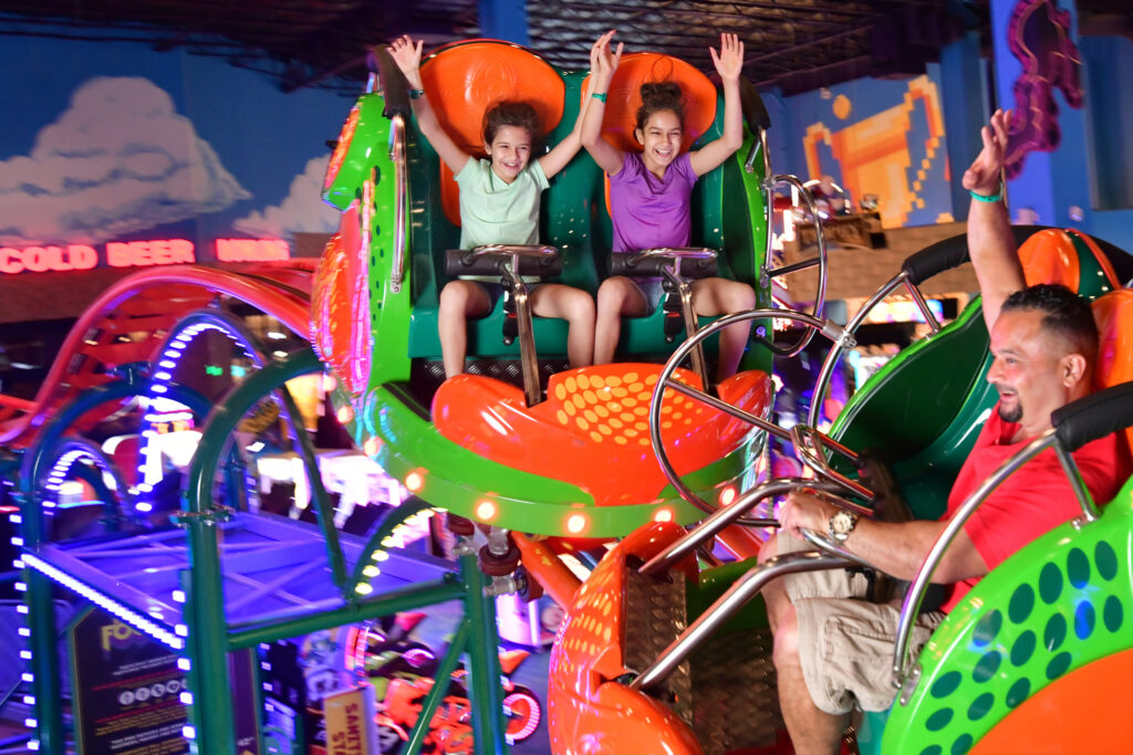 Image of people on an indoor rolercoaster ride.