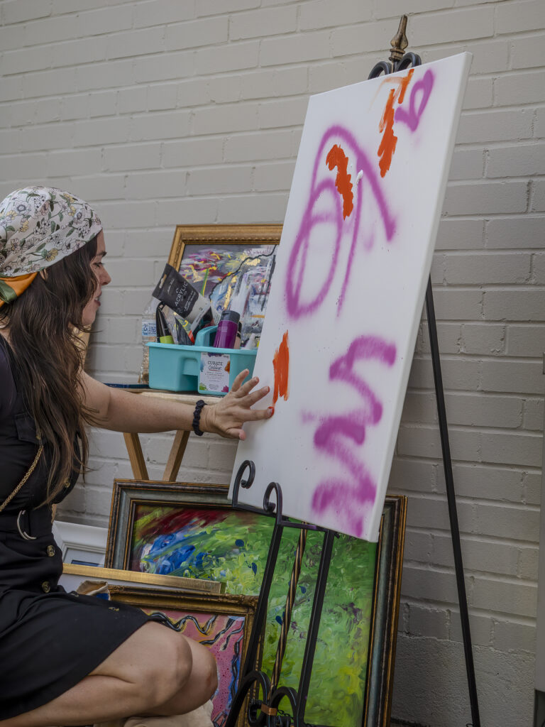 Artist Courtney Brewer begins a live art demo at an Art Stroll event
