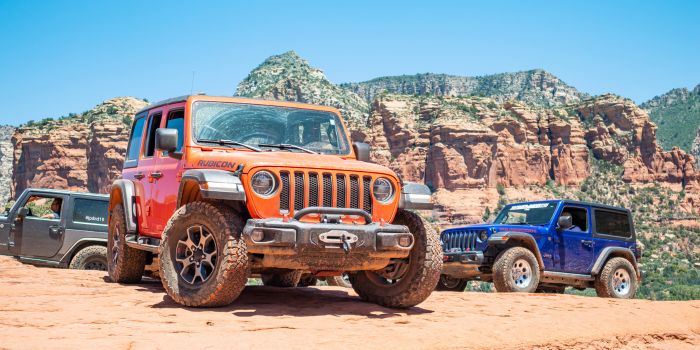 Three Jeep Wranglers on a rugged off-road trail