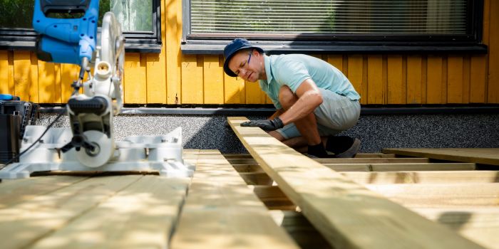 Homeowner building a backyard deck with a miter saw